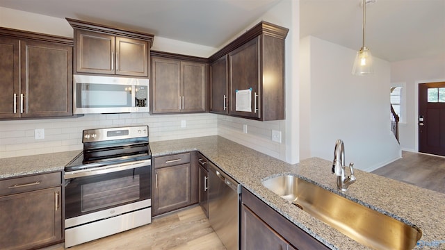 209 Roman Randall Rd, New Market, AL 35761 - kitchen featuring dark brown cabinets, light stone countertops, appliances with stainless steel finishes, light wood finished floors, and a sink