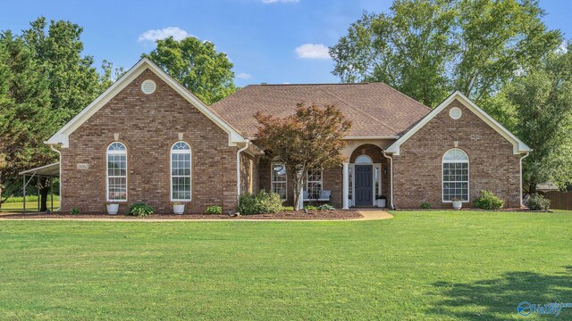view of front of home featuring a front lawn and brick siding