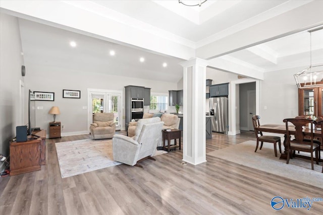 living room featuring an inviting chandelier, ornamental molding, beam ceiling, and hardwood / wood-style floors