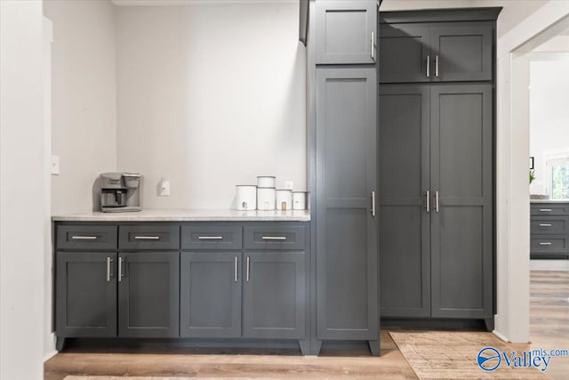 bar featuring gray cabinets and light hardwood / wood-style floors