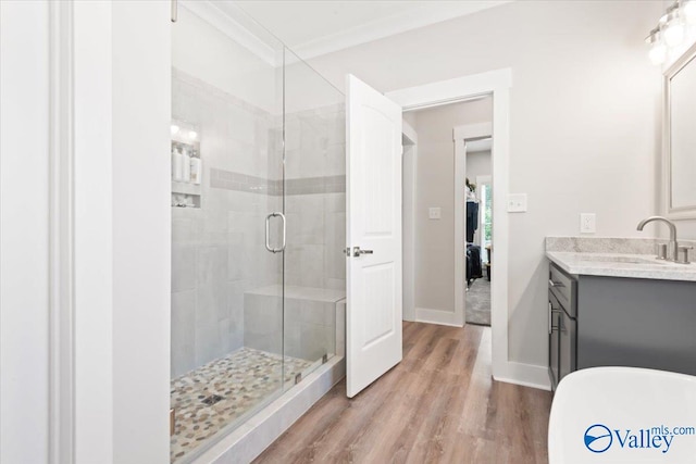 bathroom featuring walk in shower, vanity, crown molding, and hardwood / wood-style flooring