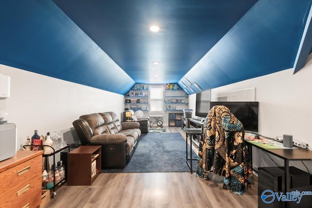 living room featuring lofted ceiling and light hardwood / wood-style floors