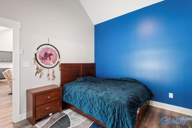 bedroom featuring lofted ceiling and hardwood / wood-style flooring