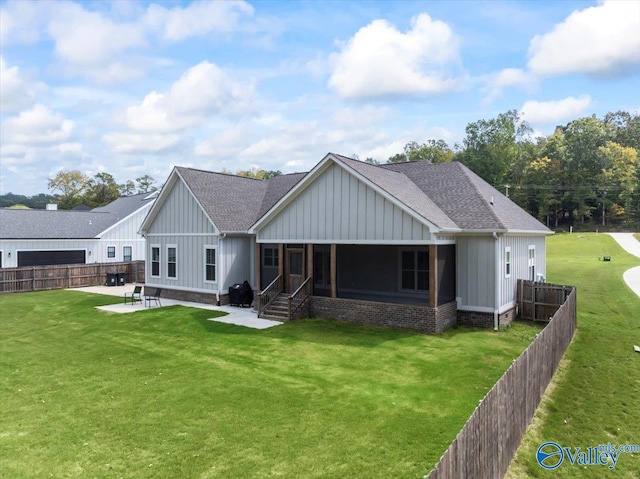 rear view of house with a lawn, a sunroom, and a patio