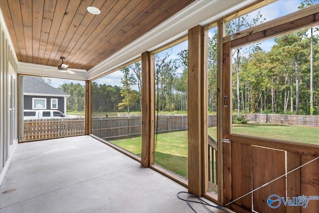 unfurnished sunroom with ceiling fan, wooden ceiling, and a wealth of natural light