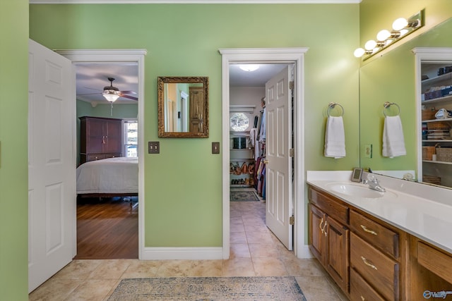 ensuite bathroom featuring vanity, ensuite bath, a ceiling fan, and tile patterned flooring