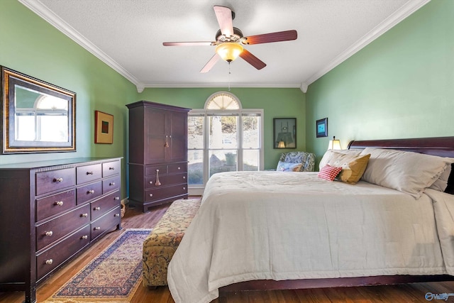 bedroom featuring a ceiling fan, a textured ceiling, wood finished floors, and ornamental molding