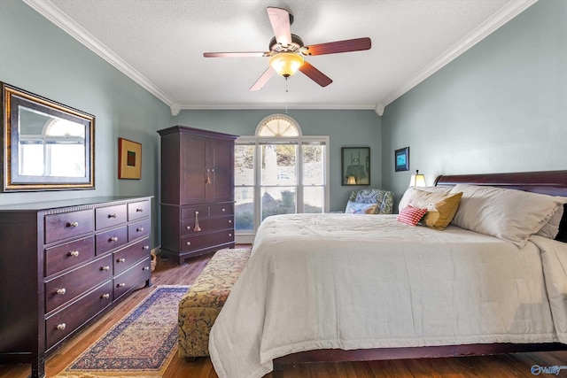 bedroom with ceiling fan, a textured ceiling, wood finished floors, and crown molding