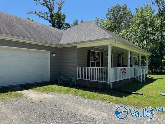 117 Simmons Cir, Fayetteville, TN 37334 - view of property exterior featuring covered porch, an attached garage, a lawn, and a shingled roof