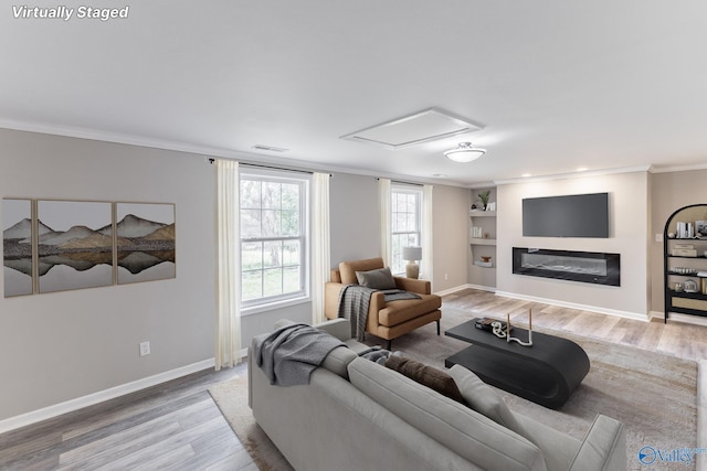 living area with visible vents, built in shelves, baseboards, ornamental molding, and light wood-style flooring