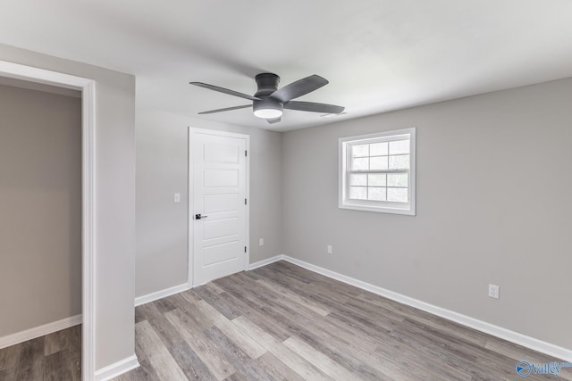 unfurnished bedroom with baseboards, wood finished floors, and a ceiling fan