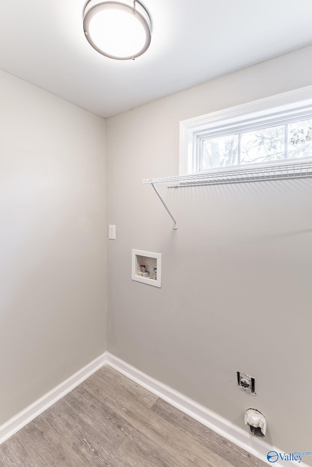 laundry area featuring laundry area, washer hookup, baseboards, and wood finished floors
