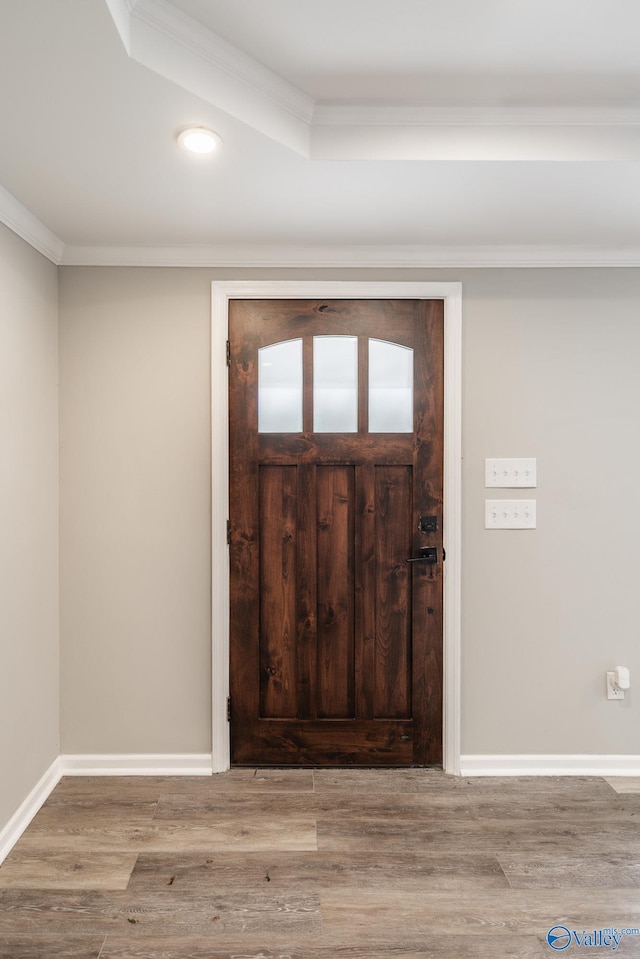 entryway featuring ornamental molding, baseboards, and wood finished floors