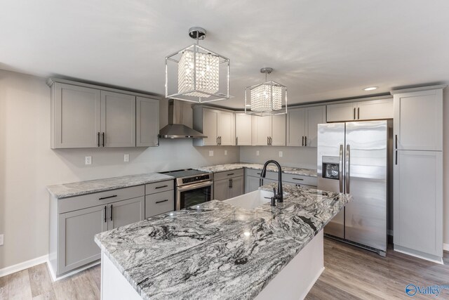 kitchen featuring wall chimney exhaust hood, gray cabinets, and stainless steel appliances