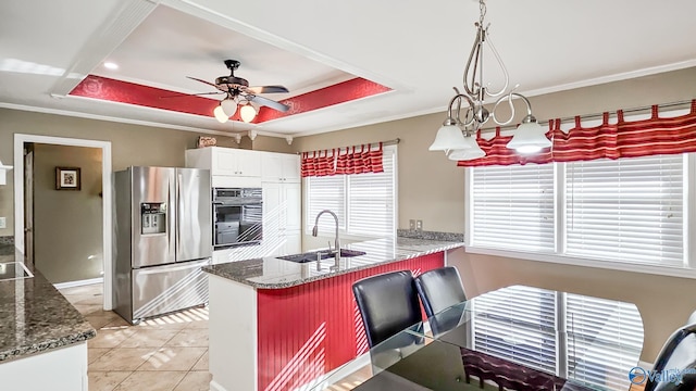 kitchen with pendant lighting, sink, white cabinetry, stainless steel refrigerator with ice dispenser, and a raised ceiling