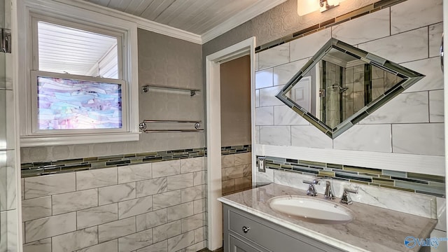 bathroom featuring vanity, ornamental molding, and tile walls