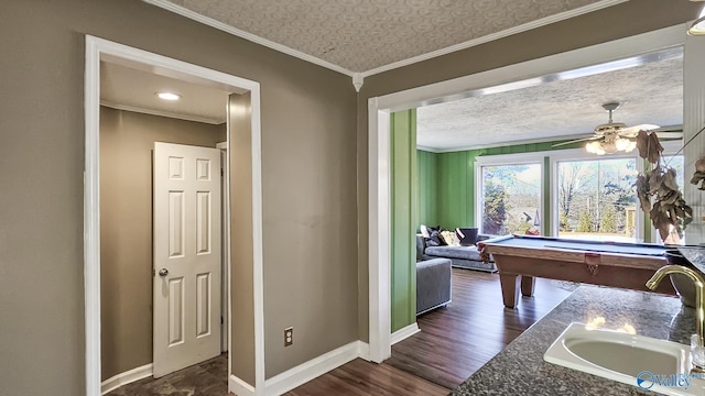 rec room featuring sink, crown molding, dark wood-type flooring, billiards, and a textured ceiling