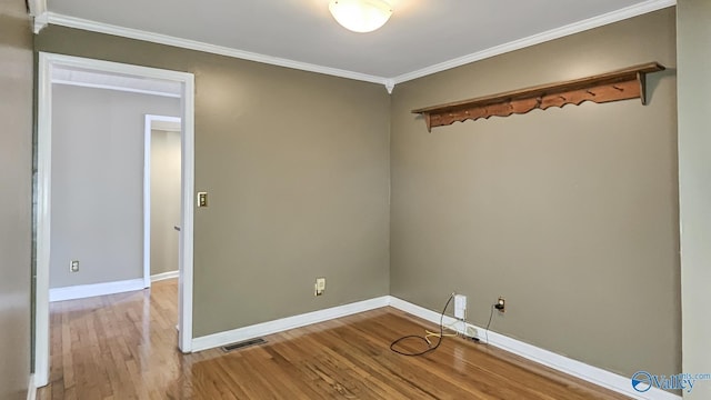 spare room with ornamental molding and light hardwood / wood-style floors