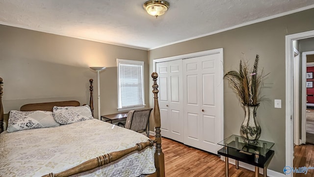 bedroom with ornamental molding, hardwood / wood-style floors, and a closet