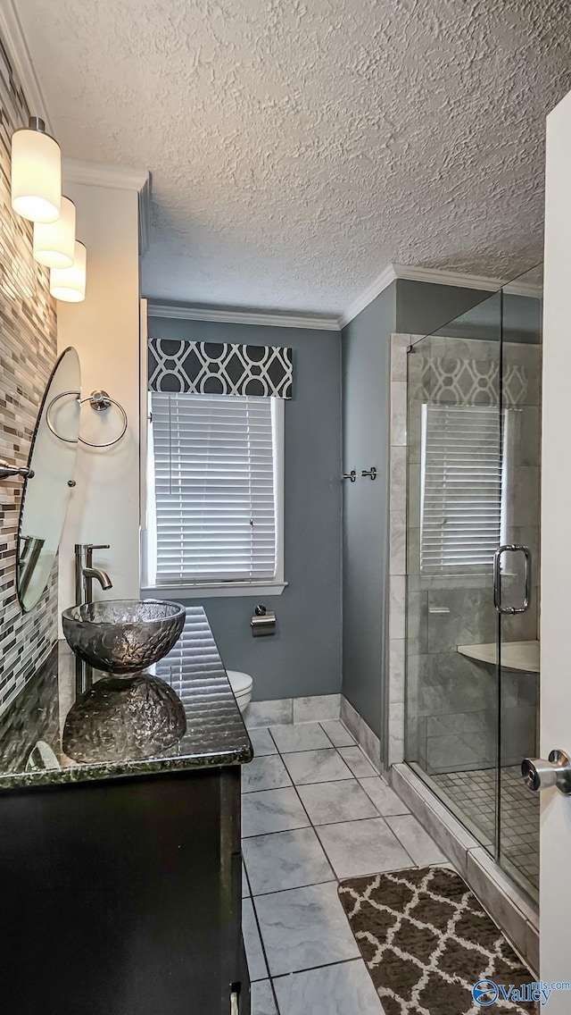 bathroom with toilet, crown molding, a textured ceiling, vanity, and a shower with door