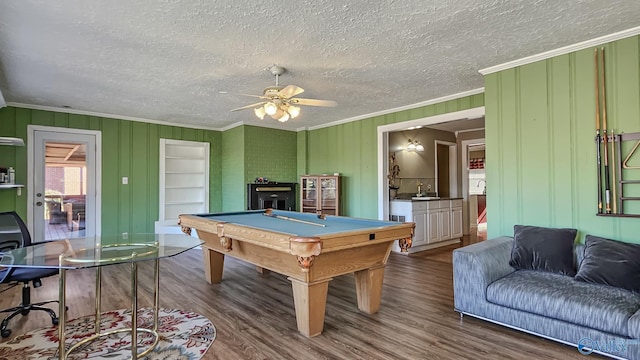 game room featuring pool table, a textured ceiling, ornamental molding, hardwood / wood-style flooring, and ceiling fan