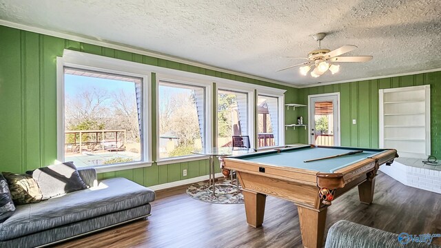 game room featuring dark hardwood / wood-style floors, ornamental molding, pool table, ceiling fan, and a textured ceiling