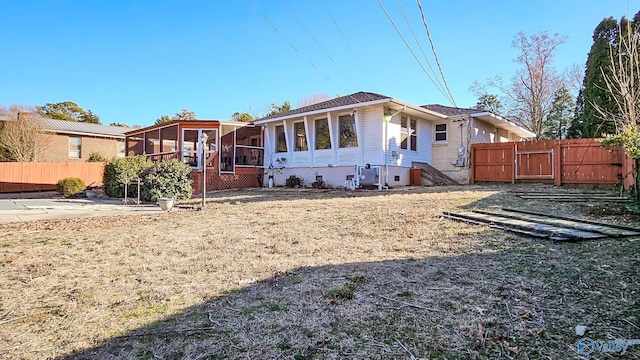 view of front facade with a front lawn, a patio area, and a sunroom