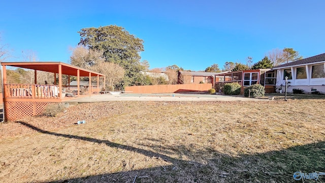 view of yard featuring a wooden deck, a sunroom, and a patio