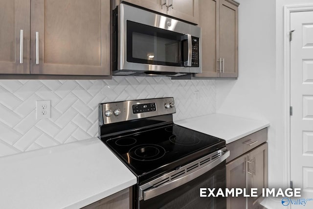 kitchen with appliances with stainless steel finishes and tasteful backsplash