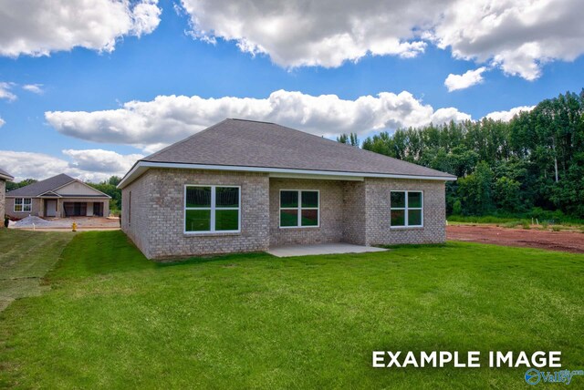 rear view of property featuring a lawn and a patio