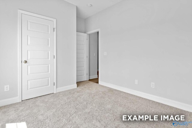 unfurnished bedroom with light colored carpet