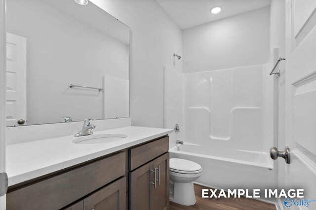 full bathroom with hardwood / wood-style floors, vanity, toilet, and shower / bathtub combination