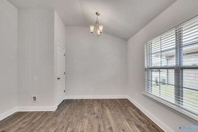 empty room with an inviting chandelier, vaulted ceiling, a wealth of natural light, and dark hardwood / wood-style flooring