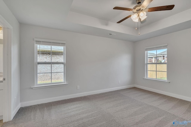 unfurnished room featuring ceiling fan, a raised ceiling, and carpet floors