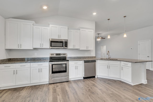 kitchen featuring sink, appliances with stainless steel finishes, kitchen peninsula, pendant lighting, and white cabinets