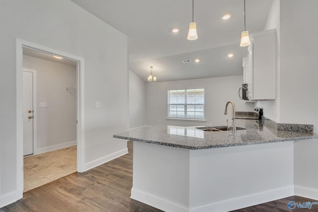 kitchen featuring white cabinetry, light stone countertops, sink, and hanging light fixtures