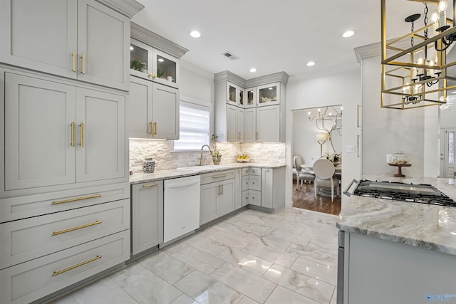 kitchen featuring a sink, tasteful backsplash, crown molding, dishwasher, and a chandelier