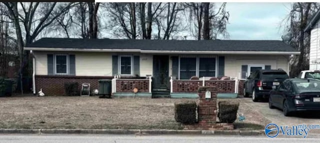 single story home featuring brick siding and a porch
