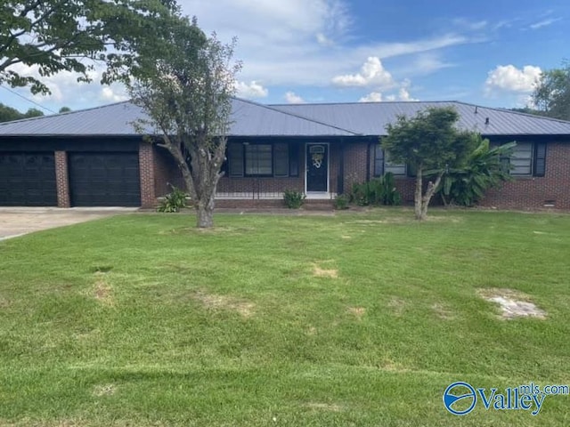 ranch-style home featuring a front lawn, concrete driveway, a garage, and metal roof