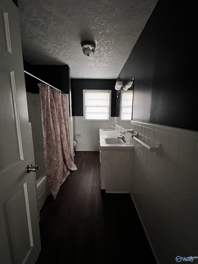 bathroom featuring vanity, a textured ceiling, wainscoting, and toilet