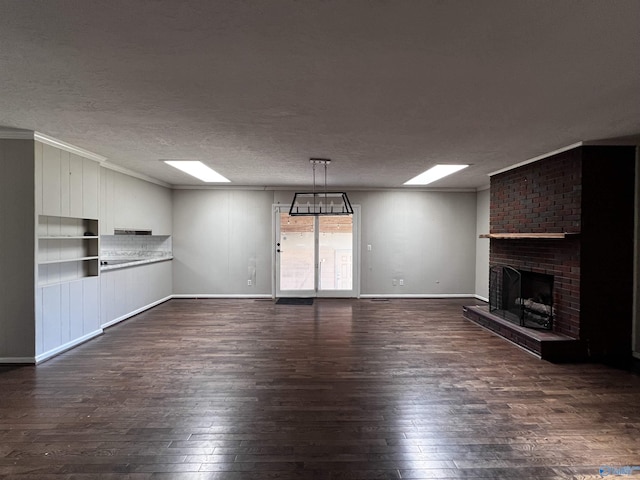 unfurnished living room featuring a textured ceiling, dark wood finished floors, a fireplace, and ornamental molding