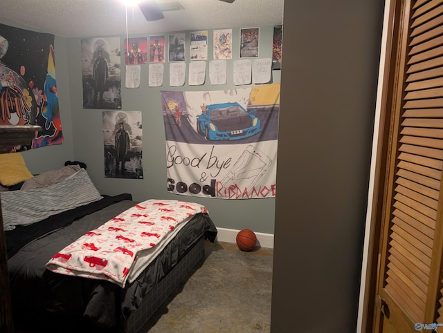 bedroom featuring ceiling fan, concrete flooring, and a textured ceiling