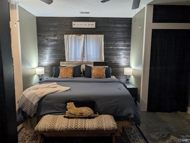 carpeted bedroom with ceiling fan, a textured ceiling, and wooden walls