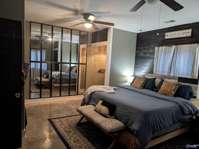 bedroom with ceiling fan, a textured ceiling, and concrete floors