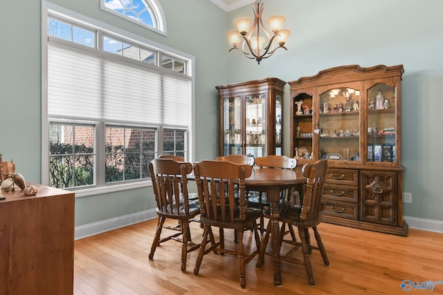 dining space with a wealth of natural light, an inviting chandelier, baseboards, and light wood-style floors
