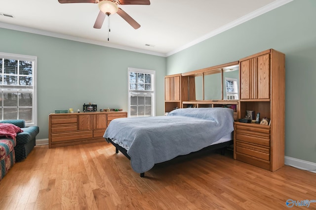 bedroom featuring a ceiling fan, baseboards, visible vents, light wood finished floors, and crown molding