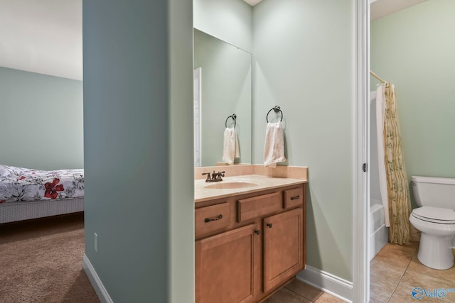 bathroom featuring tile patterned flooring, baseboards, shower / bath combo with shower curtain, toilet, and vanity