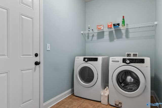 laundry room with washer and clothes dryer, laundry area, baseboards, and light tile patterned floors
