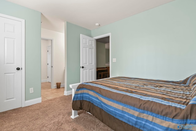 carpeted bedroom featuring tile patterned floors and baseboards