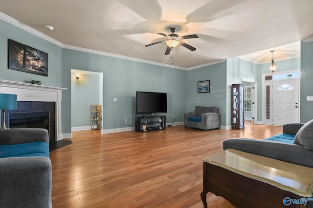 living area featuring ceiling fan, wood finished floors, and crown molding
